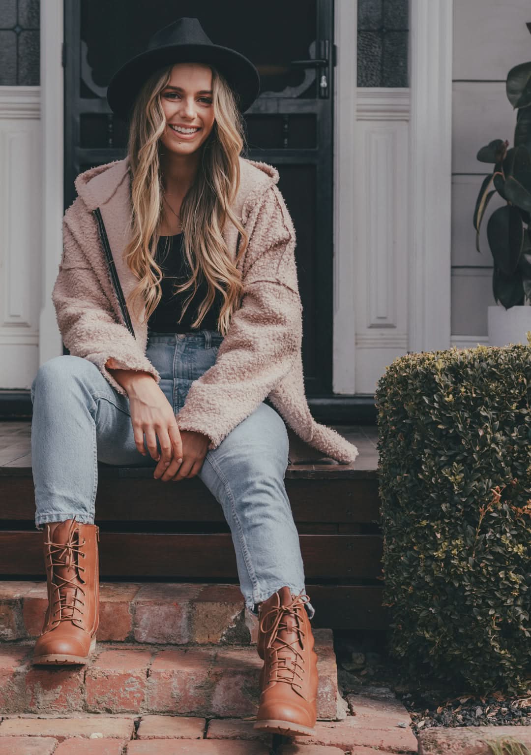 Pink sherpa fleece jacket worn with light wash jeans and tan lace-up boots, front view. - Yellow Earth Australia
