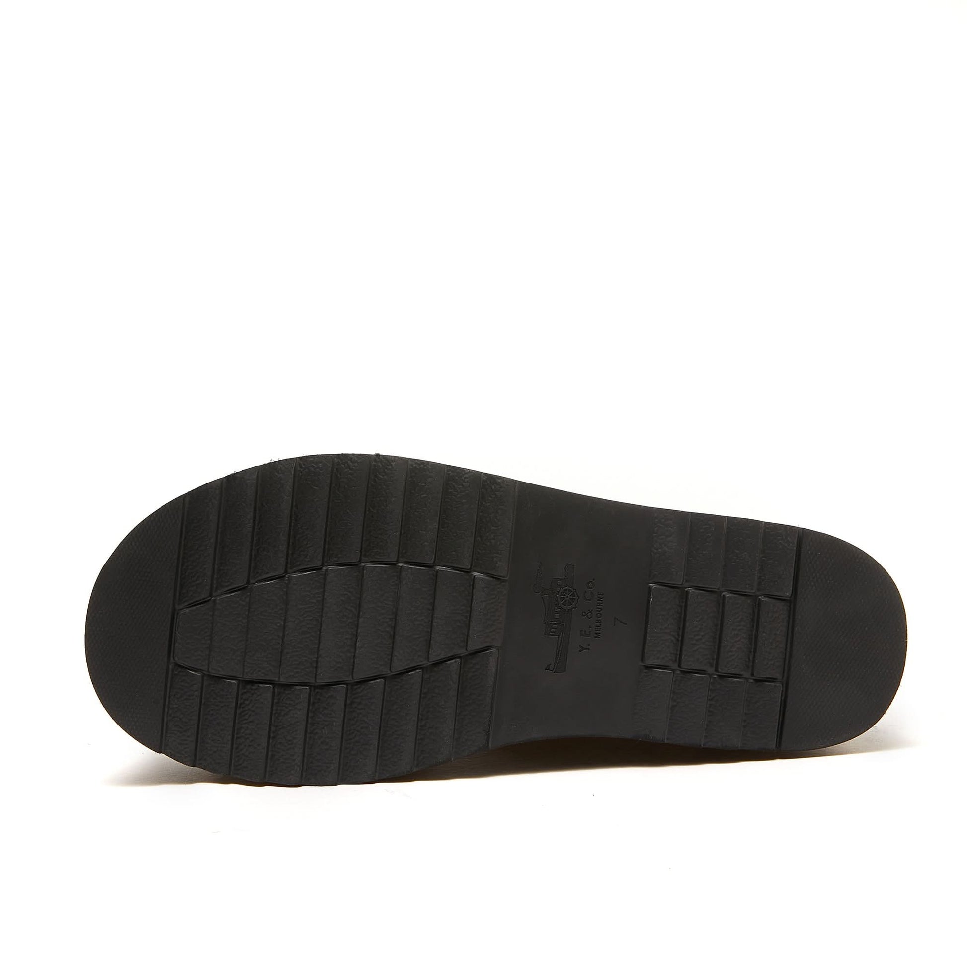Black sheepskin slipper sole viewed from underneath showing textured rubber grip pattern. - Yellow Earth Australia