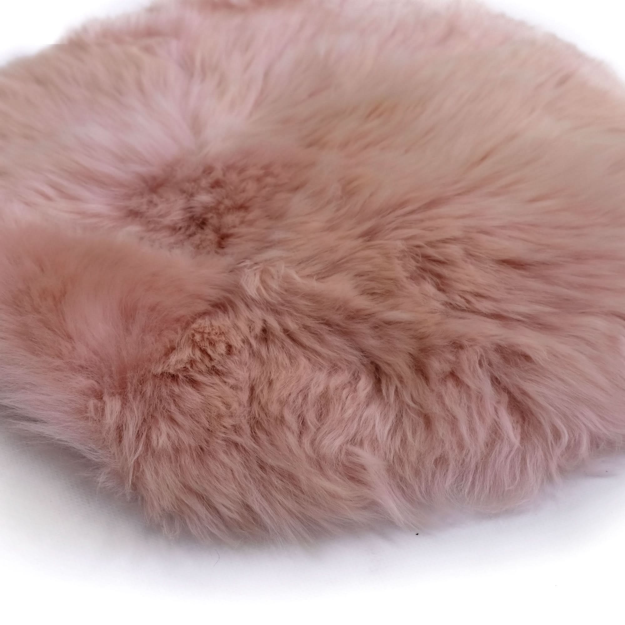 Soft pink sheepskin cushion with fluffy wool texture, top view. - Yellow Earth Australia