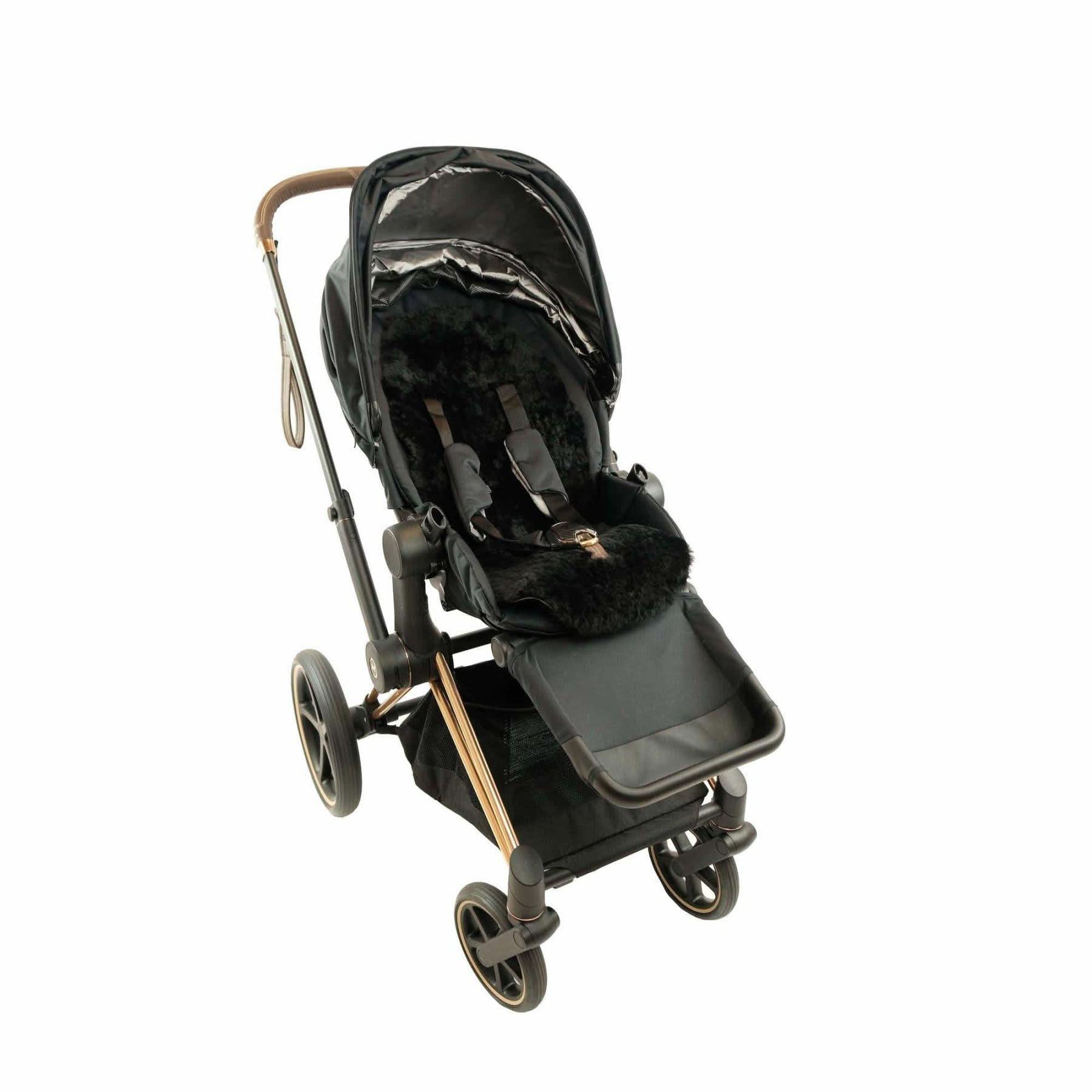 Black sheepskin pram liner viewed from above on luxury stroller with bronze accents. - Yellow Earth Australia
