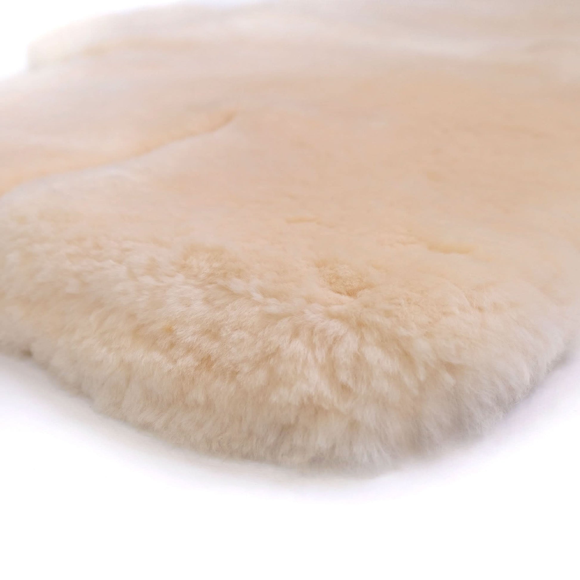 Natural sheepskin rug with soft wool fleece, viewed from above on white background. - Yellow Earth Australia