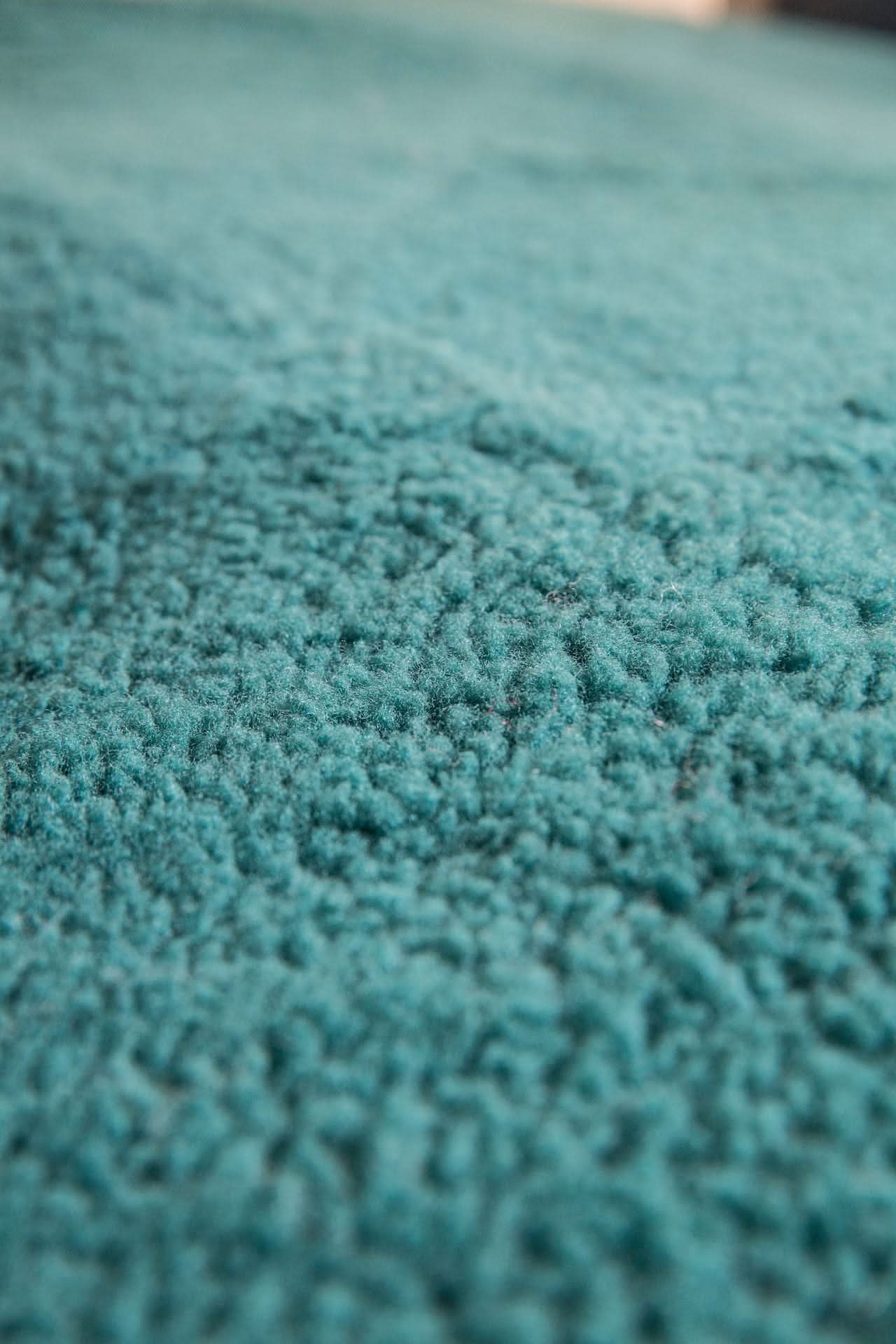 Close-up view of soft teal sheepskin wool texture showing fine fiber detail. - Yellow Earth Australia