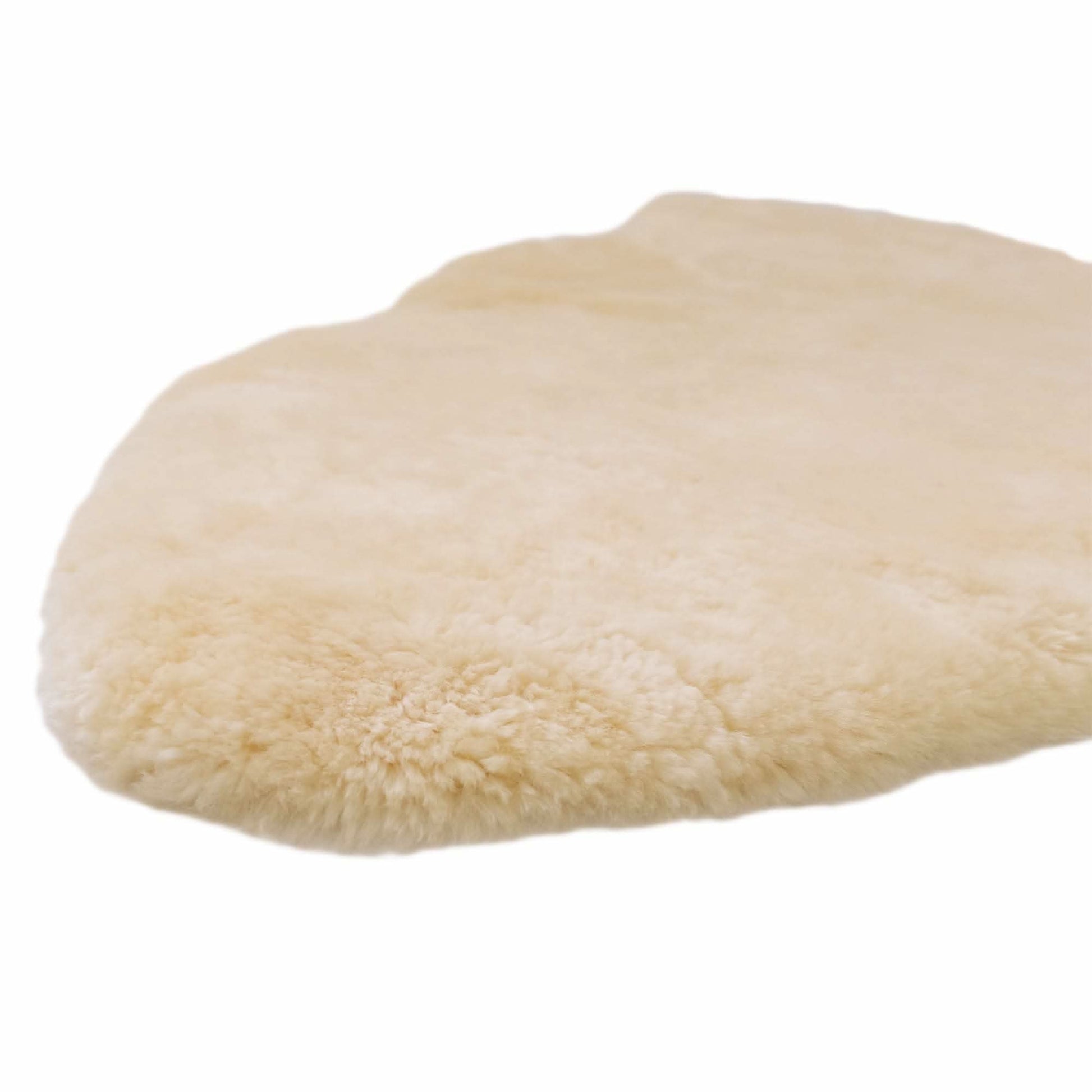 Cream sheepskin rug with soft wool pile, viewed from above at an angle. - Yellow Earth Australia