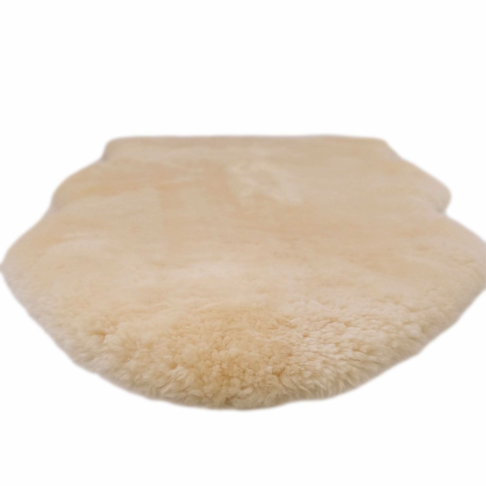 Cream sheepskin seat cover with fluffy wool texture, top view. - Yellow Earth Australia