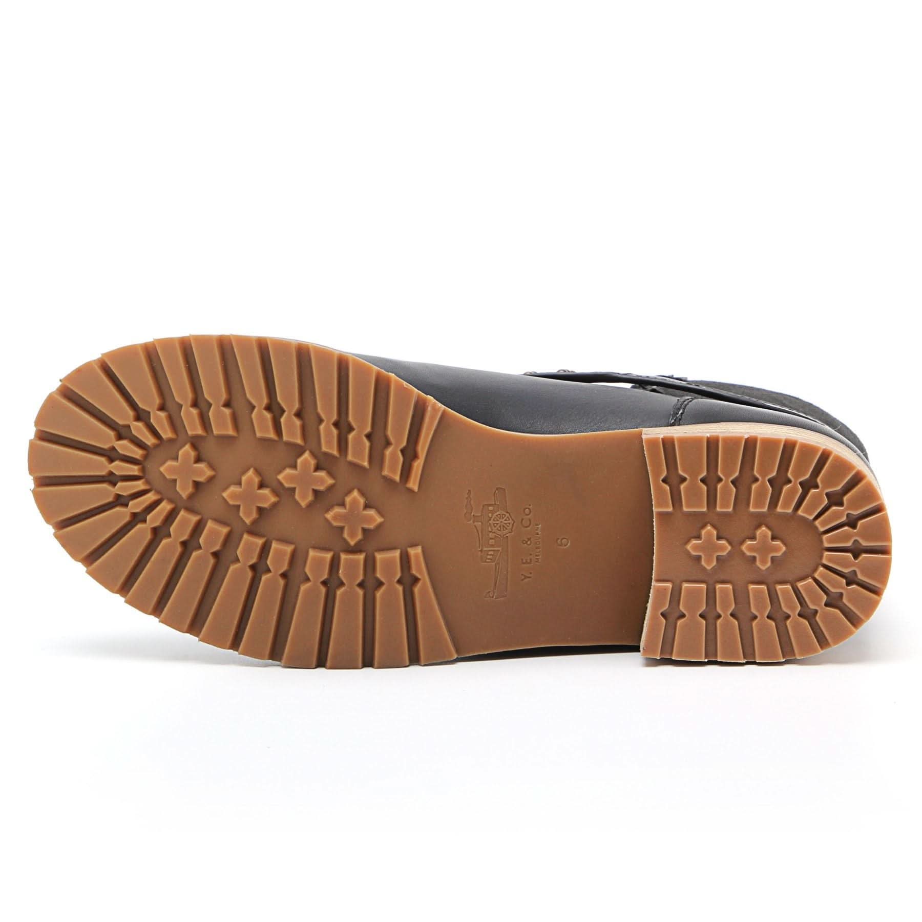 Tan crepe sole on black leather shoe viewed from underneath showing tread pattern. - Yellow Earth Australia