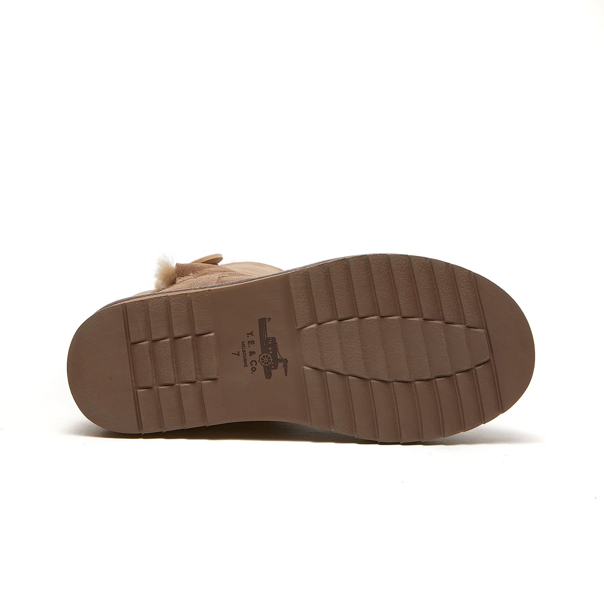 Beige sheepskin boot with treaded rubber sole shown from bottom view, size 7.