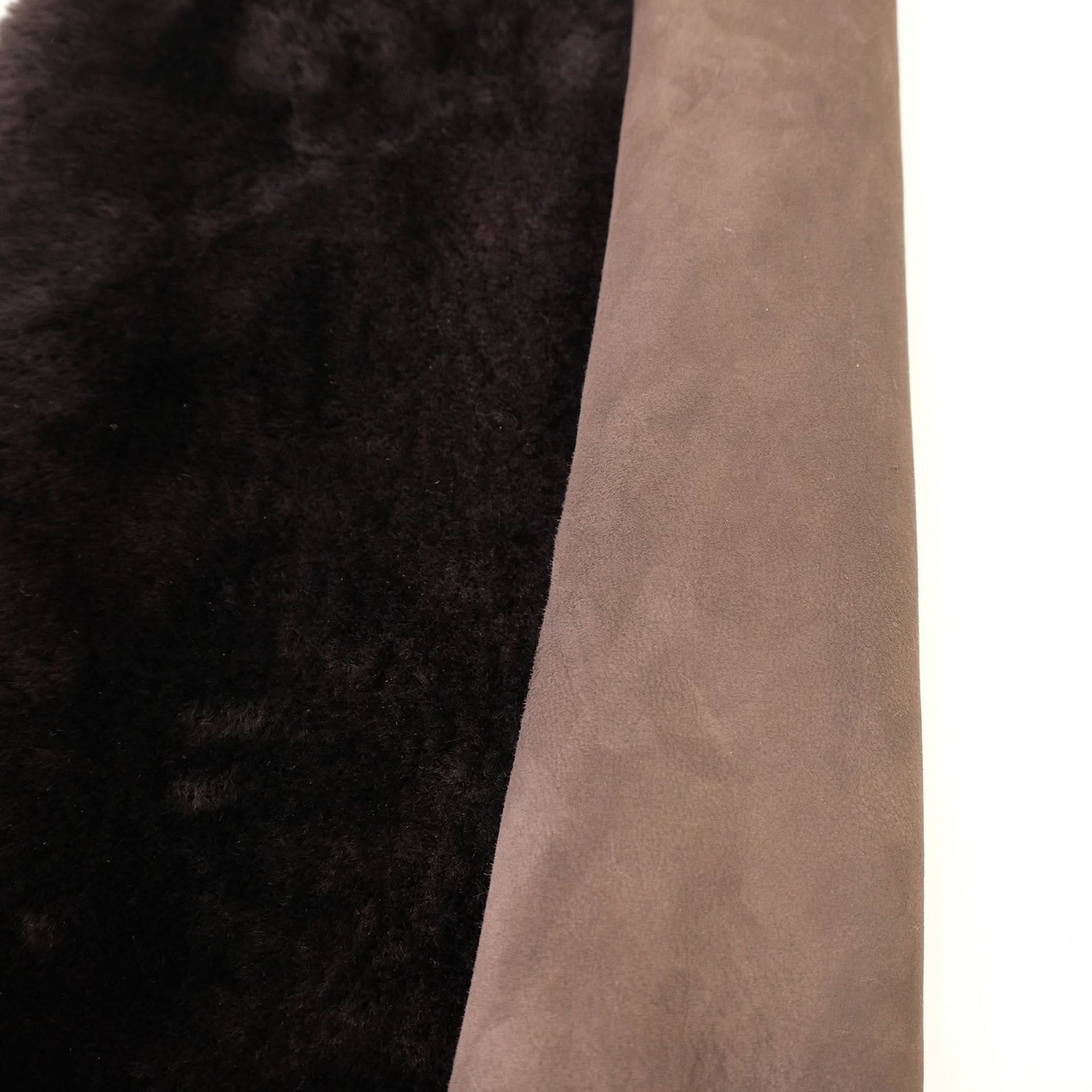 Black and beige sheepskin rug showing contrasting wool and suede textures side by side. - Yellow Earth Australia