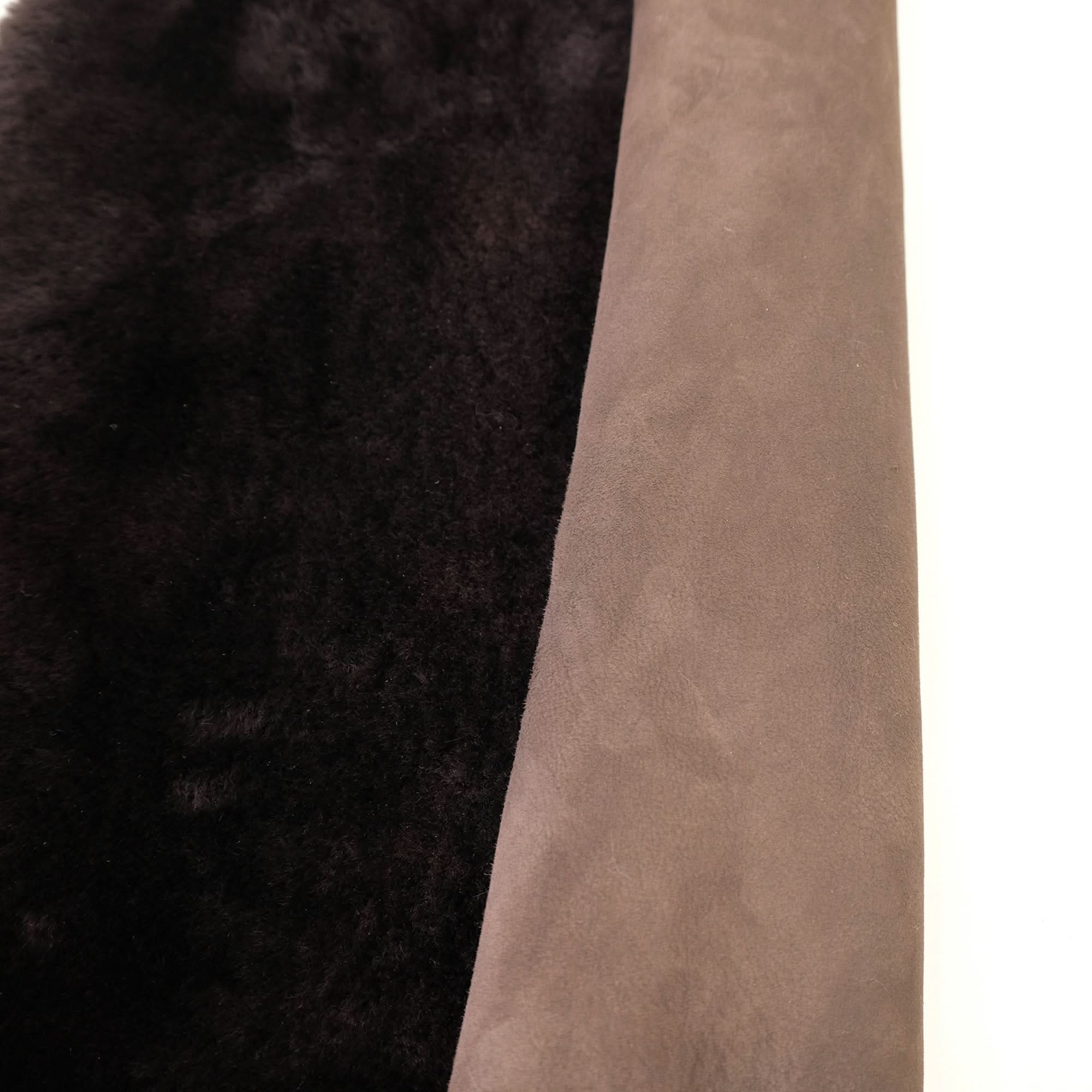 Black and beige sheepskin rug showing contrasting wool and suede textures side by side. - Yellow Earth Australia