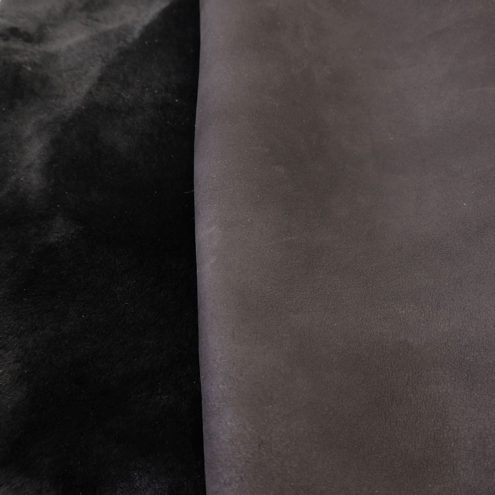 Black and charcoal sheepskin rugs displayed side by side showing soft wool texture. - Yellow Earth Australia
