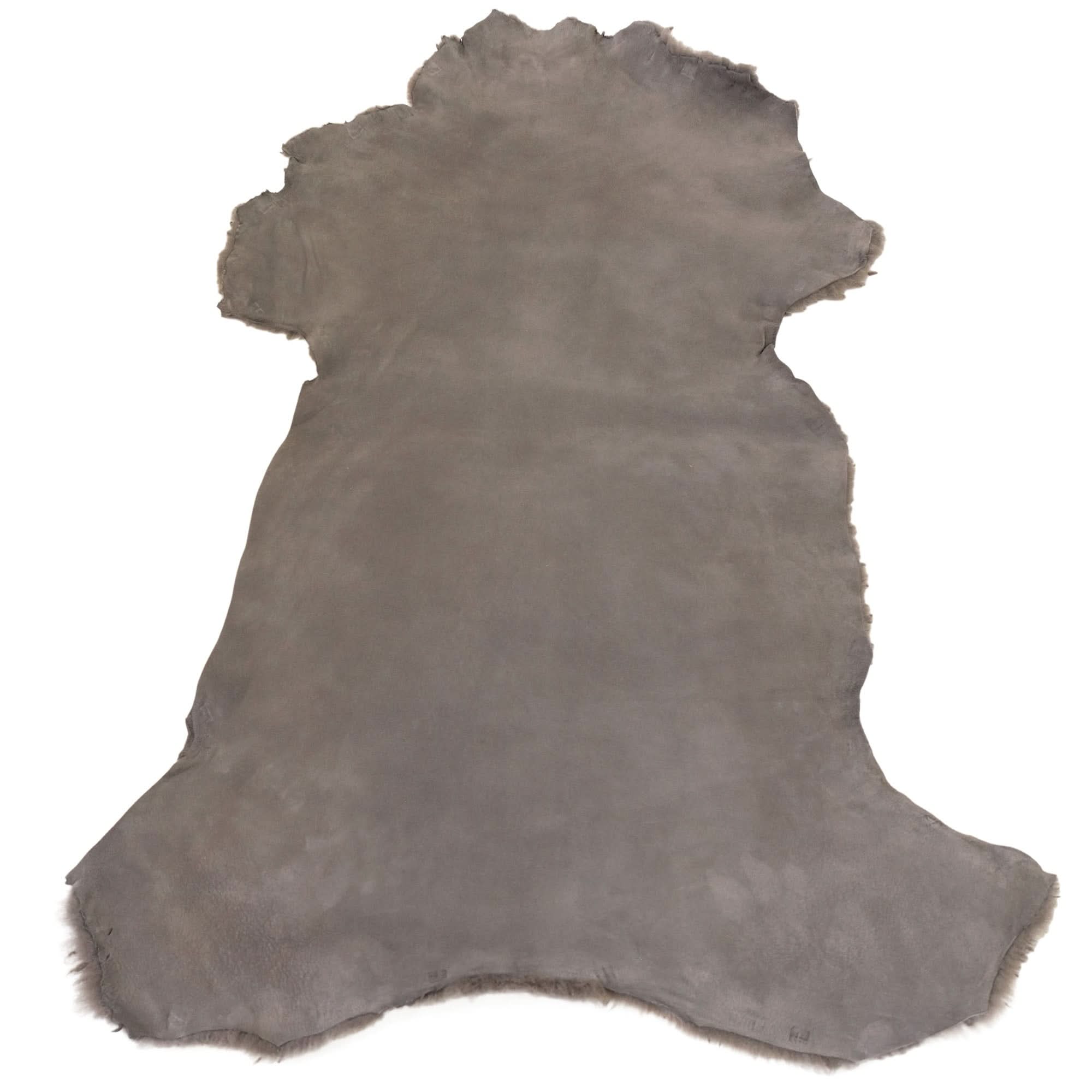 Grey sheepskin rug with natural wool texture, viewed from above on white background. - Yellow Earth Australia