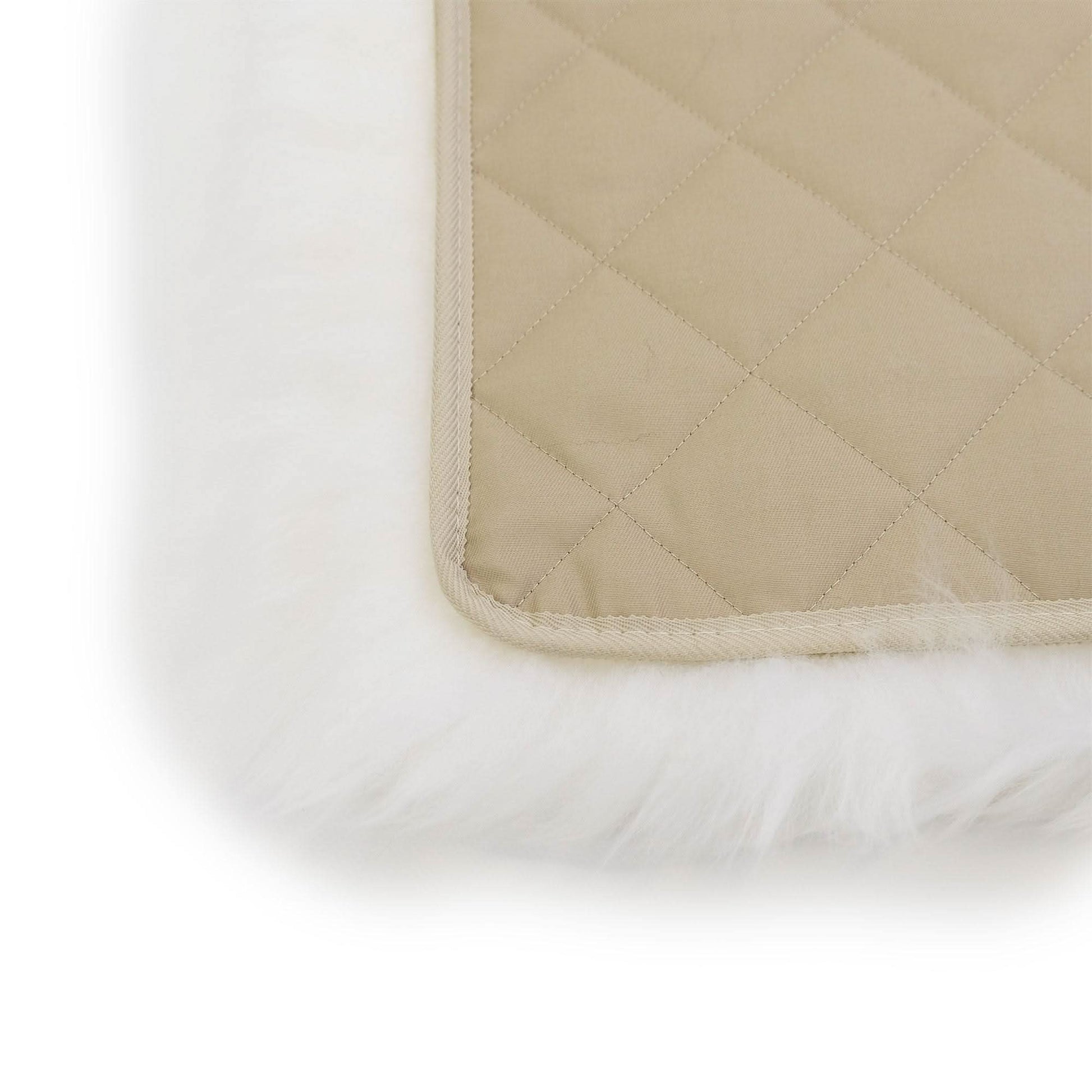 Quilted wool underlay with cream binding and white sheepskin base, corner detail view. - Yellow Earth Australia